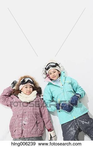Stock Photo - Young Japanese women wearing snowboard wear on white background. Fotosearch