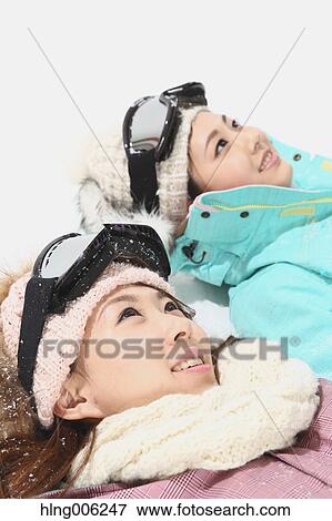 Stock Photo - Young Japanese women wearing snowboard wear on white background. Fotosearch