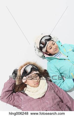 Stock Photo - Young Japanese women wearing snowboard wear on white background. Fotosearch
