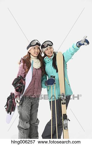 Stock Photo - Young Japanese women wearing snowboard wear on white background. Fotosearch
