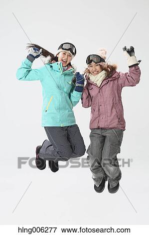 Stock Photo - Young Japanese women wearing snowboard wear on white background. Fotosearch