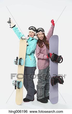Stock Photograph - Young Japanese women wearing snowboard wear on white background. Fotosearch
