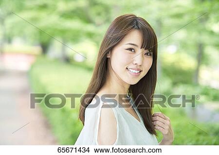 Attractive Japanese woman in a city park View Large Photo Image Picture - Attractive Japanese woman in a city park. Fotosearch