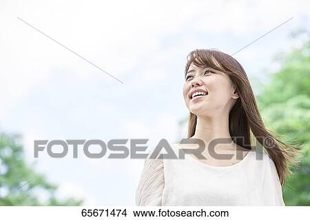 Picture - Attractive Japanese woman in a city park. Fotosearch