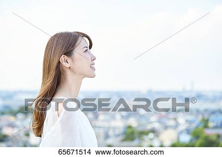 Picture - Attractive Japanese woman in a city park. Fotosearch