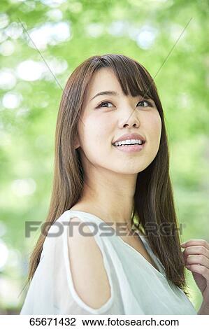 Attractive Japanese woman in a city park View Large Photo Image Stock Image - Attractive Japanese woman in a city park. Fotosearch