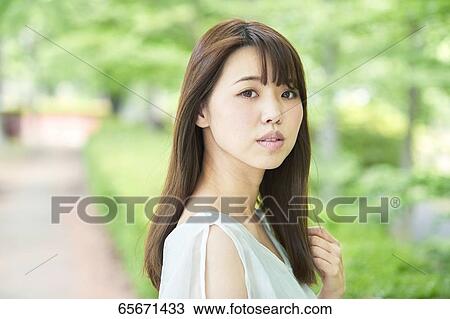 Attractive Japanese woman in a city park View Large Photo Image Stock Image - Attractive Japanese woman in a city park. Fotosearch
