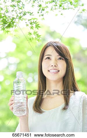 Attractive Japanese woman in a city park View Large Photo Image Stock Image - Attractive Japanese woman in a city park. Fotosearch