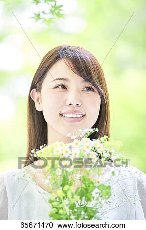 Stock Image - Attractive Japanese woman in a city park. Fotosearch