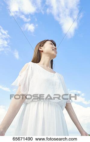 Stock Image - Attractive Japanese woman in a city park. Fotosearch