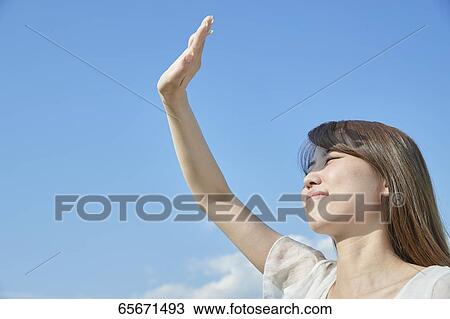 Stock Image - Attractive Japanese woman in a city park. Fotosearch