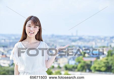 Stock Image - Attractive Japanese woman in a city park. Fotosearch