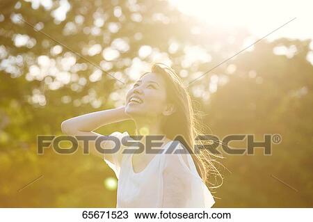 Stock Image - Attractive Japanese woman in a city park. Fotosearch
