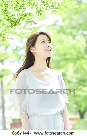 Attractive Japanese woman in a city park View Large Photo Image Stock Photo - Attractive Japanese woman in a city park. Fotosearch