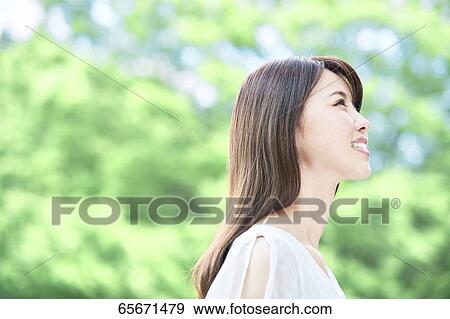 Stock Photo - Attractive Japanese woman in a city park. Fotosearch