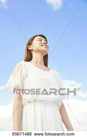 Stock Photo - Attractive Japanese woman in a city park. Fotosearch