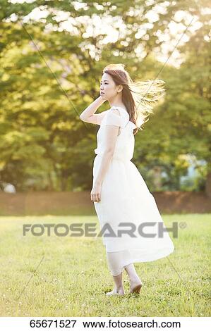 Attractive Japanese woman in a city park View Large Photo Image Stock Photo - Attractive Japanese woman in a city park. Fotosearch