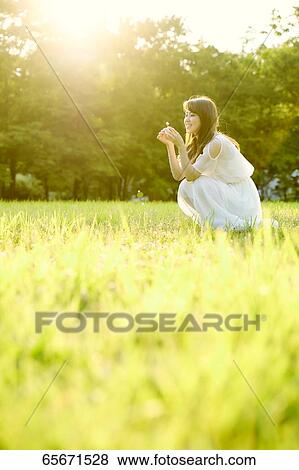 Attractive Japanese woman in a city park View Large Photo Image Stock Photo - Attractive Japanese woman in a city park. Fotosearch