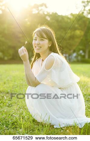 Attractive Japanese woman in a city park View Large Photo Image Stock Photo - Attractive Japanese woman in a city park. Fotosearch