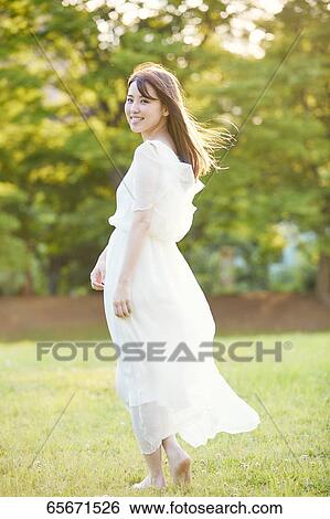Stock Photograph - Attractive Japanese woman in a city park. Fotosearch