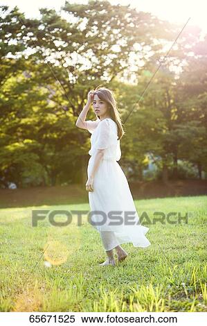 Attractive Japanese woman in a city park View Large Photo Image Stock Photography - Attractive Japanese woman in a city park. Fotosearch