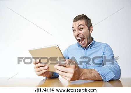 Caucasian man enjoying content on a tablet View Large Photo Image Picture - Caucasian man enjoying content on a tablet. Fotosearch