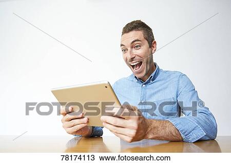 Caucasian man enjoying content on a tablet View Large Photo Image Stock Image - Caucasian man enjoying content on a tablet. Fotosearch