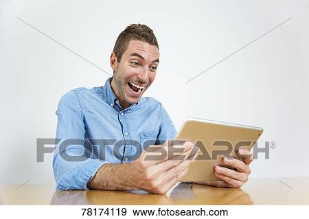 Caucasian man enjoying content on a tablet View Large Photo Image Stock Photo - Caucasian man enjoying content on a tablet. Fotosearch