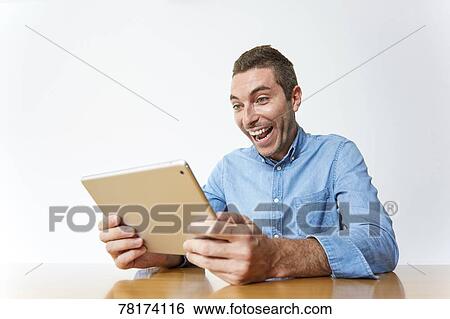 Caucasian man enjoying content on a tablet View Large Photo Image Stock Photograph - Caucasian man enjoying content on a tablet. Fotosearch