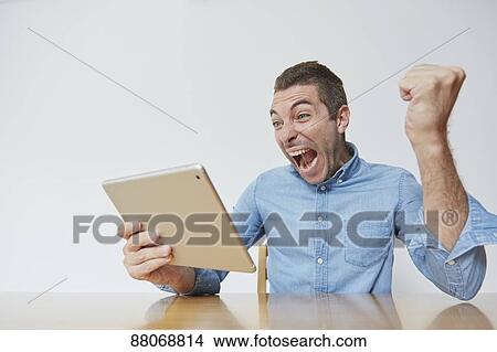 Picture - Caucasian man using tablet. Fotosearch