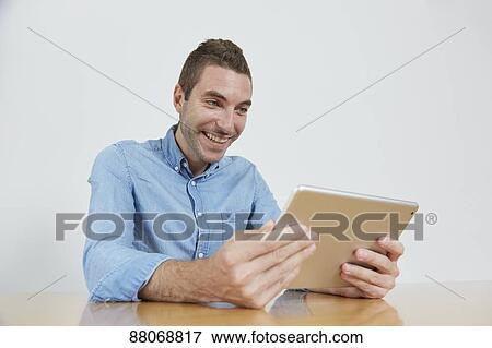 Stock Photo - Caucasian man using tablet. Fotosearch