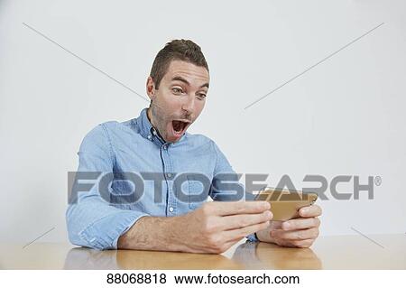Stock Photo - Caucasian man using tablet. Fotosearch