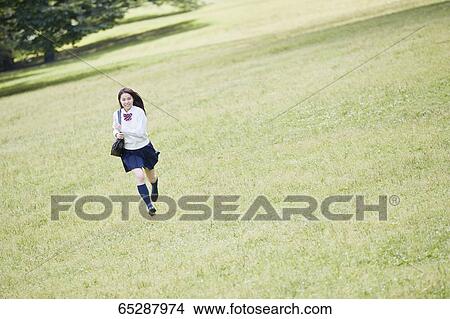 Picture - Cute Japanese high school student in a city park. Fotosearch