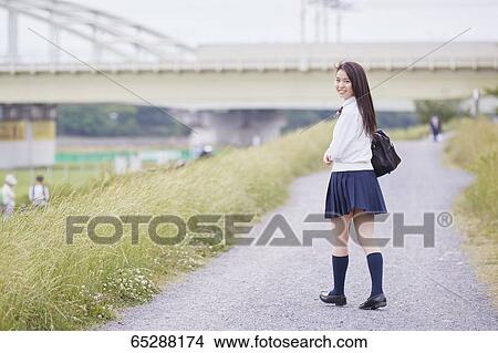 Picture - Cute Japanese high school student in a city park. Fotosearch