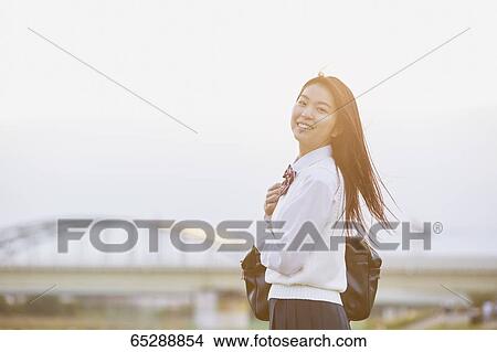 Cute Japanese high school student in a city park View Large Photo Image Picture - Cute Japanese high school student in a city park. Fotosearch