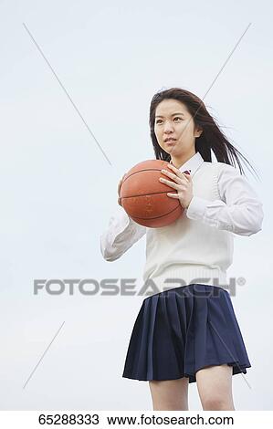 Stock Image - Cute Japanese high school student in a city park. Fotosearch