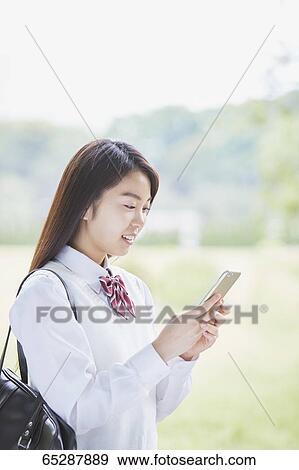 Cute Japanese high school student in a city park View Large Photo Image Stock Photo - Cute Japanese high school student in a city park. Fotosearch