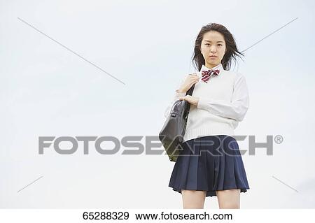 Stock Photo - Cute Japanese high school student in a city park. Fotosearch