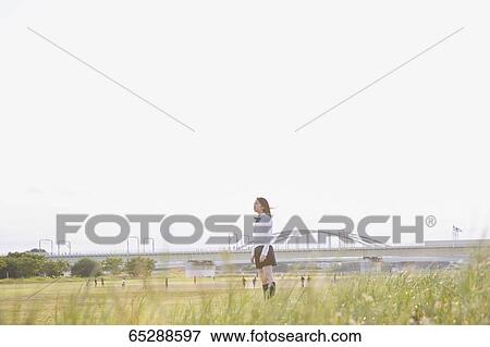 Stock Photo - Cute Japanese high school student in a city park. Fotosearch