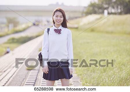 Stock Photo - Cute Japanese high school student in a city park. Fotosearch