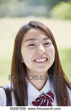 Stock Photograph - Cute Japanese high school student in a city park. Fotosearch