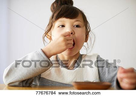 Cute Japanese kid having a snack View Large Photo Image Picture - Cute Japanese kid having a snack. Fotosearch
