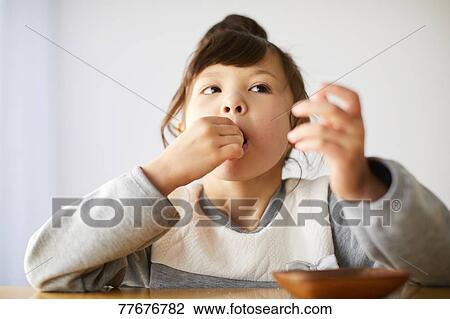 Stock Image - Cute Japanese kid having a snack. Fotosearch