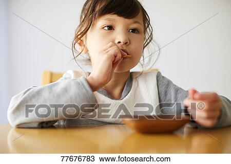 Stock Image - Cute Japanese kid having a snack. Fotosearch