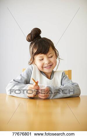 Stock Image - Cute Japanese kid having a snack. Fotosearch