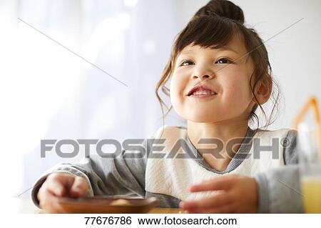 Cute Japanese kid having a snack View Large Photo Image Stock Photograph - Cute Japanese kid having a snack. Fotosearch