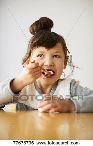 Stock Photography - Cute Japanese kid having a snack. Fotosearch