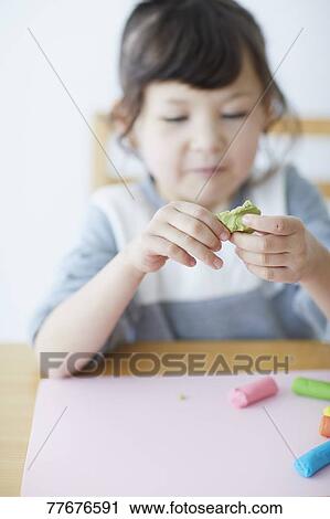 Cute Japanese kid playing with clay View Large Photo Image Stock Image - Cute Japanese kid playing with clay. Fotosearch