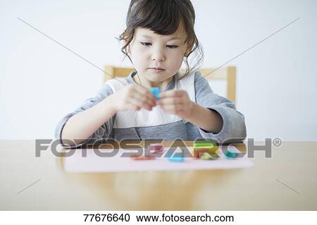Cute Japanese kid playing with clay View Large Photo Image Stock Image - Cute Japanese kid playing with clay. Fotosearch