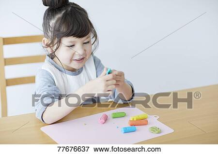 Stock Photo - Cute Japanese kid playing with clay. Fotosearch